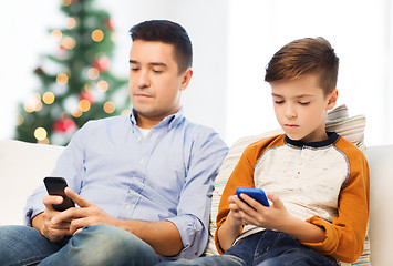 Image showing father and son with smartphones at christmas