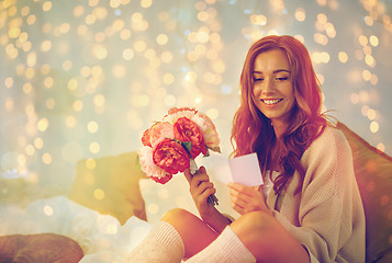 Image showing happy woman with flowers and greeting card at home