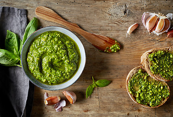 Image showing Bowl of basil pesto on wooden table