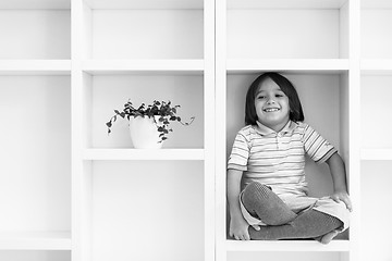 Image showing young boy posing on a shelf