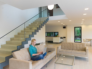 Image showing Young woman using laptop at home