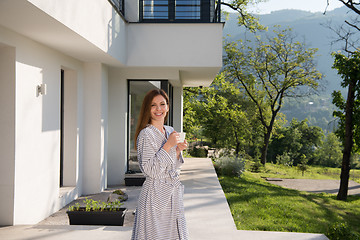 Image showing woman in a bathrobe enjoying morning coffee