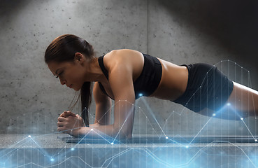 Image showing woman doing plank exercise on mat in gym