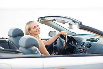 Image showing happy young woman driving convertible car