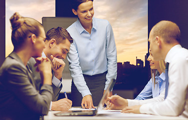 Image showing smiling female boss talking to business team