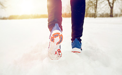 Image showing close up of feet running along snowy winter road