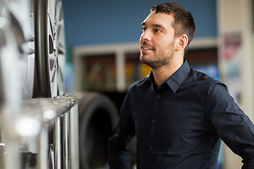 Image showing male customer choosing wheel rims at car service