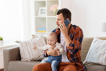 Image showing father with baby calling on smartphone at home