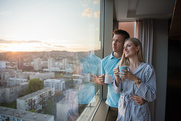 Image showing young couple enjoying evening coffee by the window