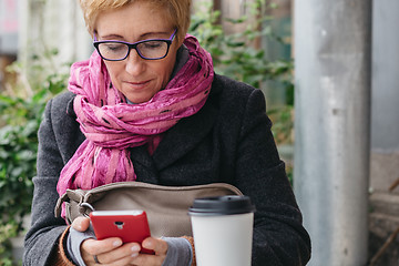 Image showing Adult woman with coffee and smartphone