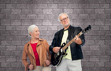 Image showing happy senior couple with electric guitar