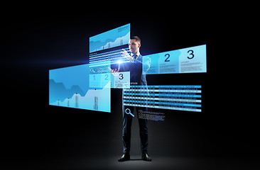 Image showing businessman with stock charts on virtual screens