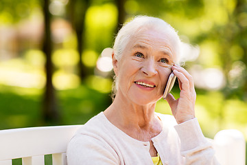 Image showing happy senior woman calling on smartphone in summer