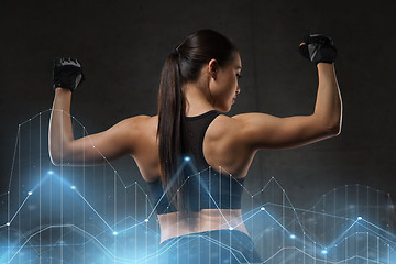 Image showing young woman flexing muscles in gym