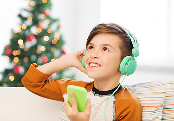 Image showing boy with smartphone and headphones at christmas