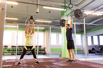 Image showing man and woman with weights exercising in gym