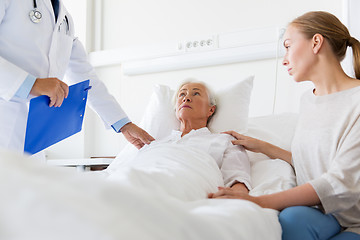 Image showing senior woman and doctor with clipboard at hospital