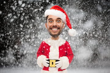 Image showing man in santa claus costume over christmas snow