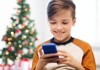 Image showing close up of happy boy with smartphone at christmas