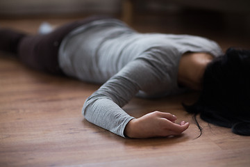 Image showing dead woman body lying on floor at crime scene