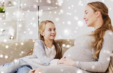 Image showing happy pregnant woman and girl on sofa at home