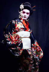 Image showing young pretty geisha in kimono with sakura and decoration