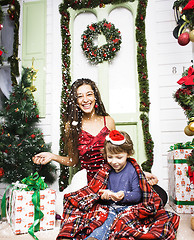 Image showing happy family on Christmas in red hats waiting gests and smiling