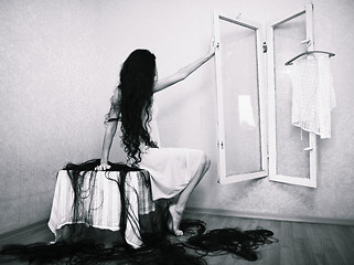 Image showing beauty girl cuting her hair in empty fearing room halloween ghost