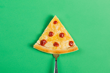Image showing Slice of pizza on a fork on a green background