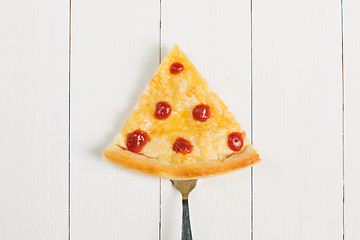 Image showing Slice of pizza on a fork on a wooden background