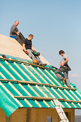 Image showing Builders at work with wooden roof construction.