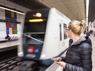 Image showing Woman with a cell phone waiting for metro.