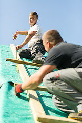 Image showing Builders at work with wooden roof construction.