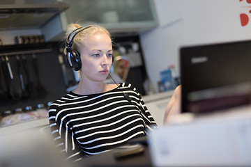 Image showing Adult woman in her casual home clothing working and studying remotely from her small flat late at night.