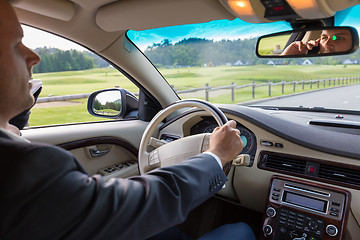 Image showing Man talking on cell phone while driving not paying attention to the road.