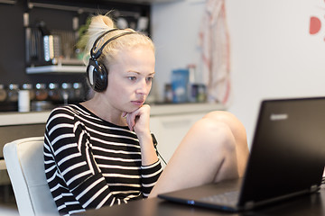 Image showing Adult woman in her casual home clothing working and studying remotely from her small flat late at night.