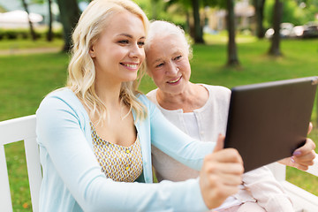 Image showing daughter with tablet pc and senior mother at park