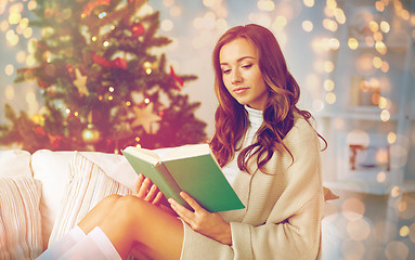 Image showing happy woman reading book at home for christmas