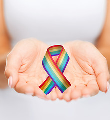 Image showing female hands holding gay pride awareness ribbon