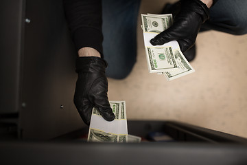 Image showing thief stealing money from safe at crime scene