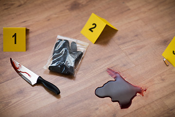 Image showing knife in blood and evidence marker at crime scene