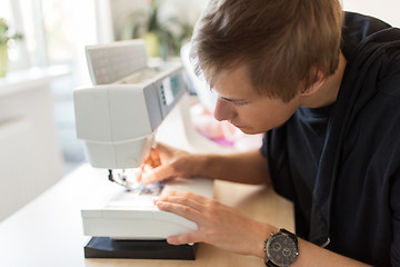 Image showing fashion designer with sewing machine at studio