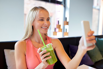 Image showing woman with smartphone taking selfie at restaurant