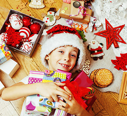 Image showing little cute boy with Christmas gifts at home. close up emotional