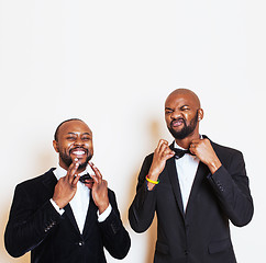 Image showing two afro-american businessmen in black suits emotional posing, gesturing, smiling. wearing bow-ties 