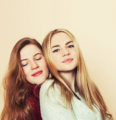 Image showing Two young girlfriends in winter sweaters indoors having fun. Lif
