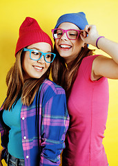 Image showing lifestyle people concept: two pretty young school teenage girls having fun happy smiling on yellow background