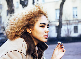 Image showing young pretty girl teenage outside smoking cigarette close up, lo