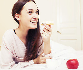 Image showing young pretty brunette woman laying in bed, luxury white interior