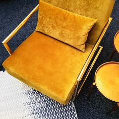 Image showing Retro style dark yellow velvet armchair and golden side table